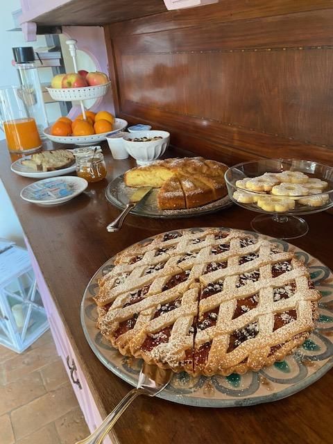 Una selezione di dolci e frutta disposti su un tavolo in legno, creando un'atmosfera accogliente.