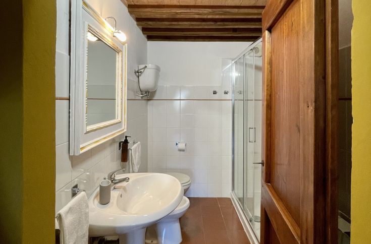 Un bagno semplice con elementi moderni e dettagli rustici, perfetto per un momento di relax.