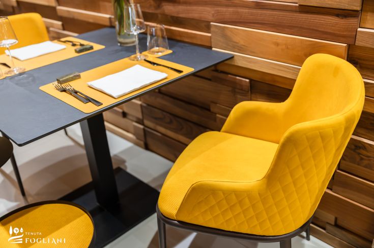 Une zone du restaurant ZERO avec une table et une chaise jaunes, dans une ambiance accueillante et soignée.