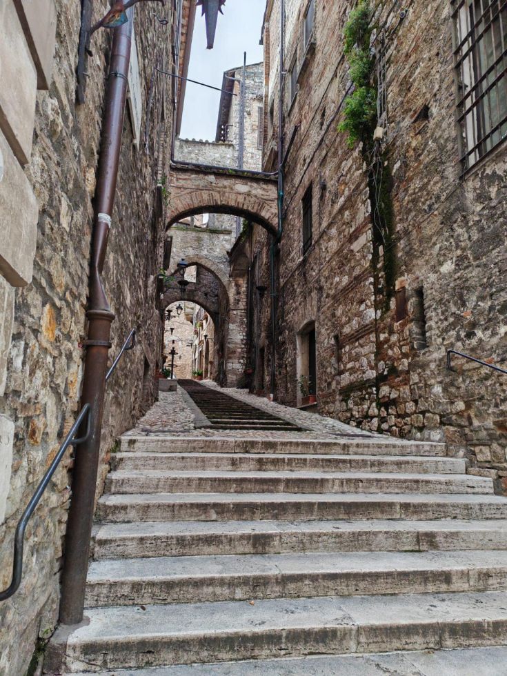 A cobblestone street in the center of Narni, surrounded by historical masonry buildings.