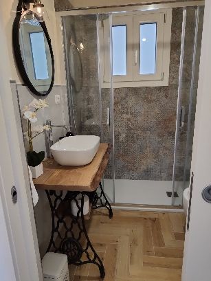 Salle de bain moderne avec douche et lavabo dans un appartement au goût raffiné.