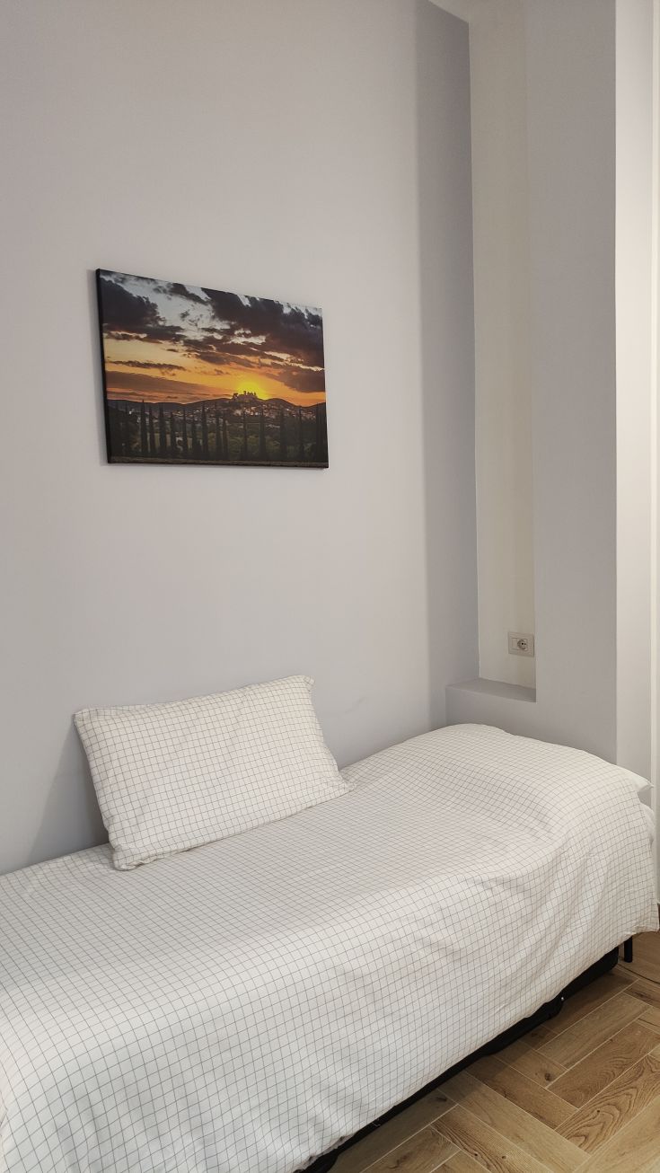 Une chambre simple avec un lit simple et une décoration sobre, idéale pour se détendre.