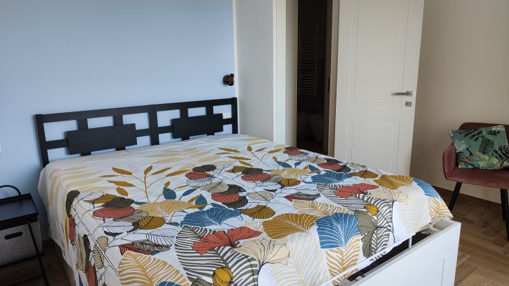 Chambre dans un appartement récemment rénové, avec du linge de lit aux couleurs vives et des meubles modernes.