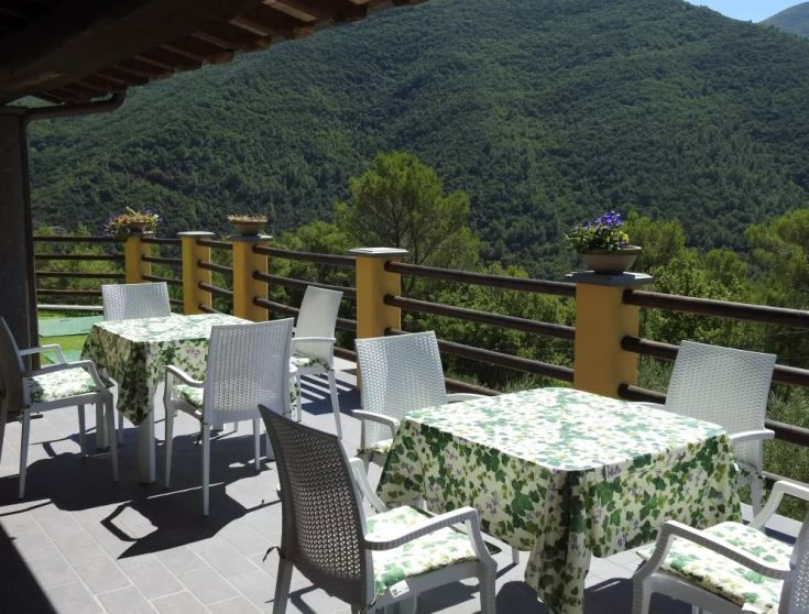Un'accogliente terrazza che si affaccia su un paesaggio montano, ideale per momenti di relax nella natura.