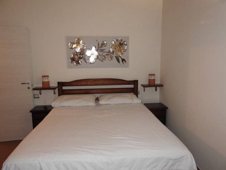 Camera semplice con letti matrimoniali e decorazioni sobrie, perfetta per riposarsi dopo una giornata di visite.