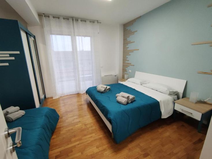 Ambiente luminoso e confortevole, arredato in modo semplice con letti comodi e dettagli moderni.