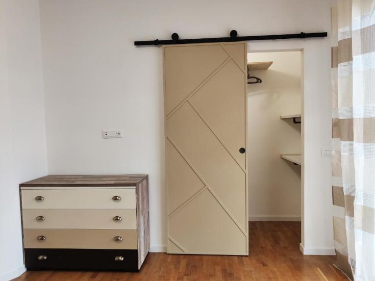 Ambiente moderno e ben illuminato con armadio a muro e mobili in legno.