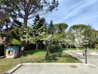 Un giardino ben tenuto con alberi e giochi per bambini, adatto per momenti di svago e relax.