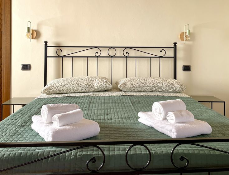 Chambre confortable avec un lit bien rangé et des serviettes pliées, parfaite pour un séjour en Ombrie.