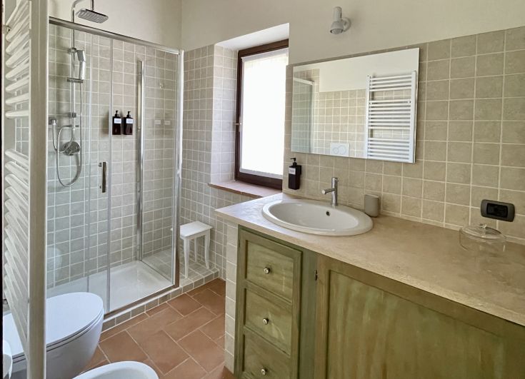 Salle de bains moderne spacieuse et bien éclairée, décorée simplement pour un confort de base.