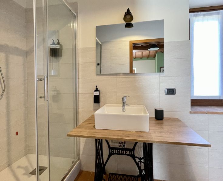 Salle de bain simple avec douche, lavabo en céramique et lumière naturelle. Espace accueillant pour le bien-être quotidien.