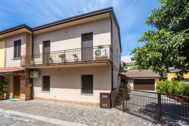 Casa con diversi balconi decorati da piante verdi, immersa in un ambiente tranquillo e accogliente. Ideale per momenti di relax.