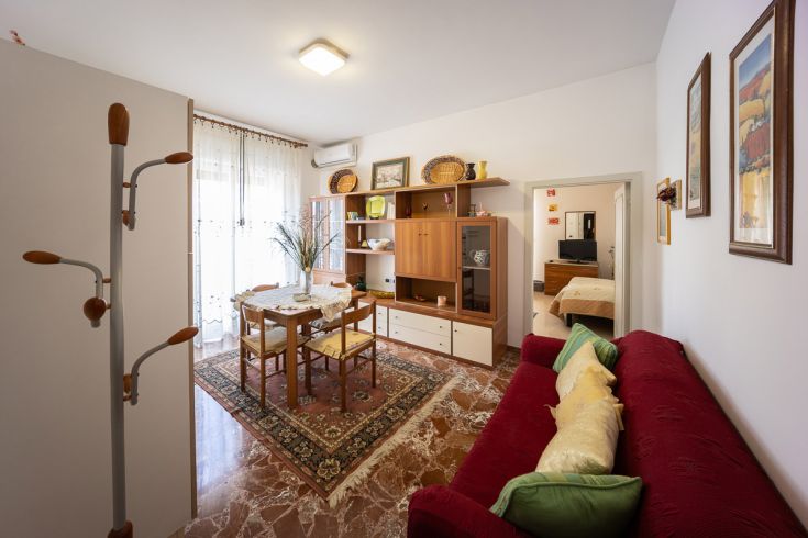 Soggiorno semplice con un tavolo da pranzo e un divano, adatto per momenti di relax.