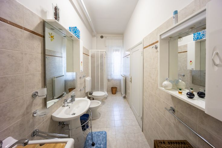 Un bagno contemporaneo e luminoso, caratterizzato da rifiniture sobrie e ben disposto.