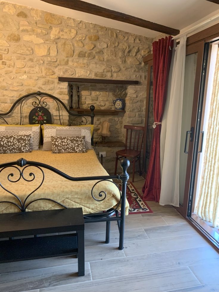 Cozy room inside a stone building, with essential elements and a view of the natural landscape.