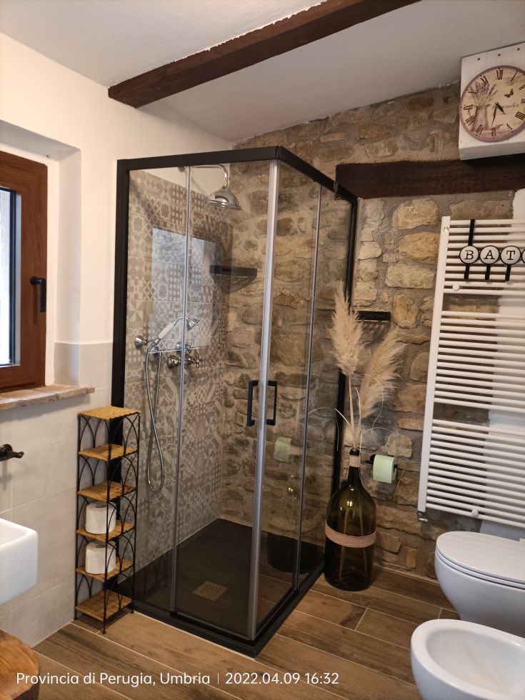 Modern bathroom with glass shower and stone finishes, perfect for relaxation.
