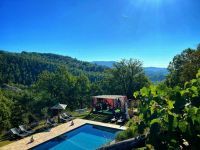 A swimming pool nestled among hills, surrounded by greenery, perfect for relaxing outdoors.