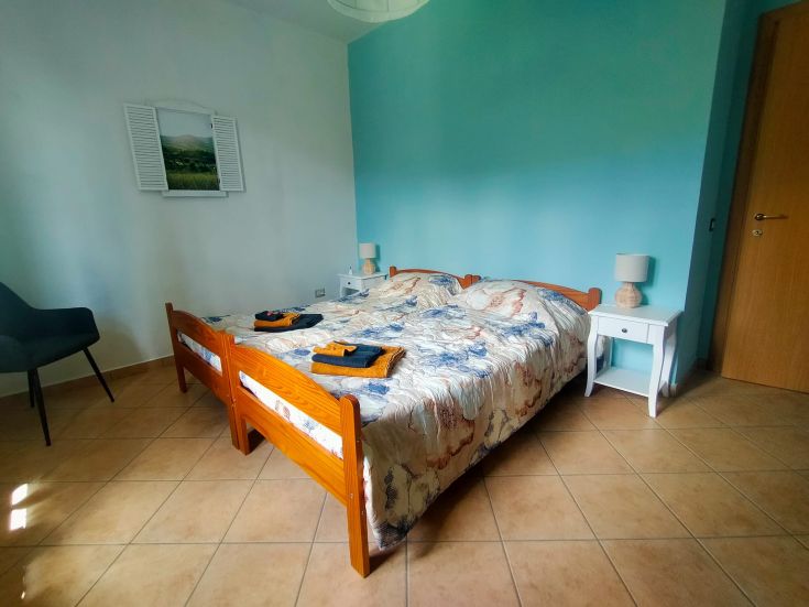 Camera ampia e ben illuminata con un letto matrimoniale, dotata di arredi semplici e confortevoli.