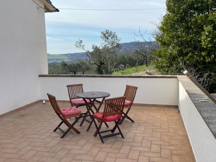 Accogliente terrazza affacciata sulla valle e sulle colline, immersa nel verde della natura umbra.