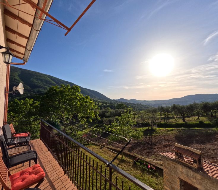 Un panorama mattutino che mostra le colline illuminate dal sole che sorge in lontananza.