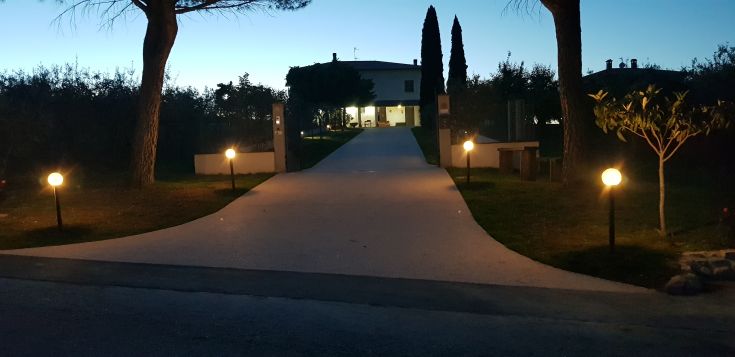 A stone path leading to a cozy agriturismo surrounded by natural scenery.