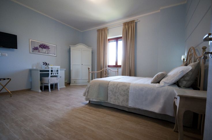 Simple room with functional furnishings and natural light, located in a peaceful agriturismo.