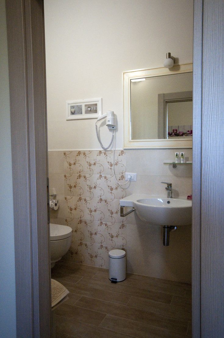 A simple and well-organized bathroom with some plants and good natural lighting.
