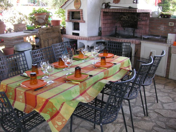 A table set for an outdoor lunch, surrounded by a natural setting.