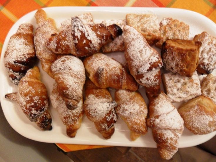 Freshly baked pastries dusted with powdered sugar, perfect for a sweet break.