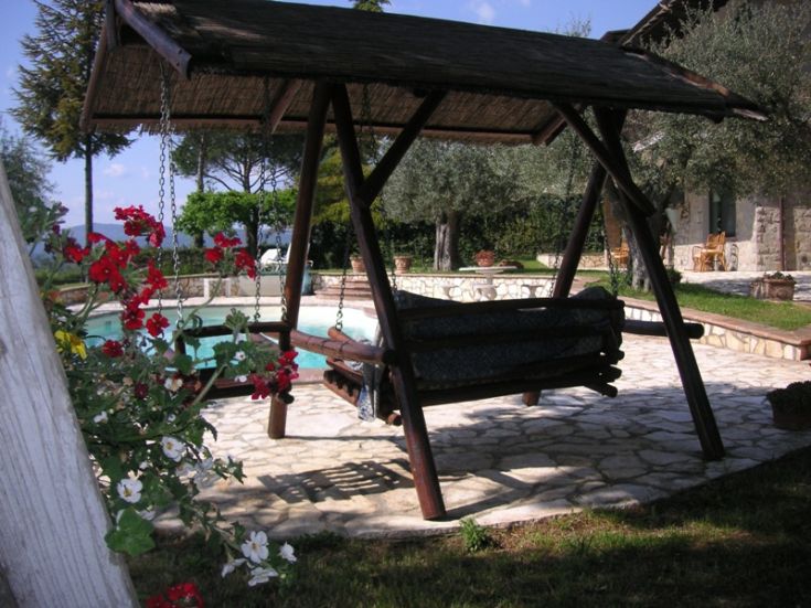 A comfortable hammock nestled in greenery, next to a pool, perfect for moments of tranquility and nature.