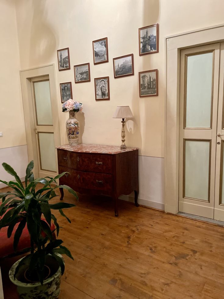 Entrata del palazzo Lauri, caratterizzata da arredi sobri e una lampada decorativa su un tavolo.