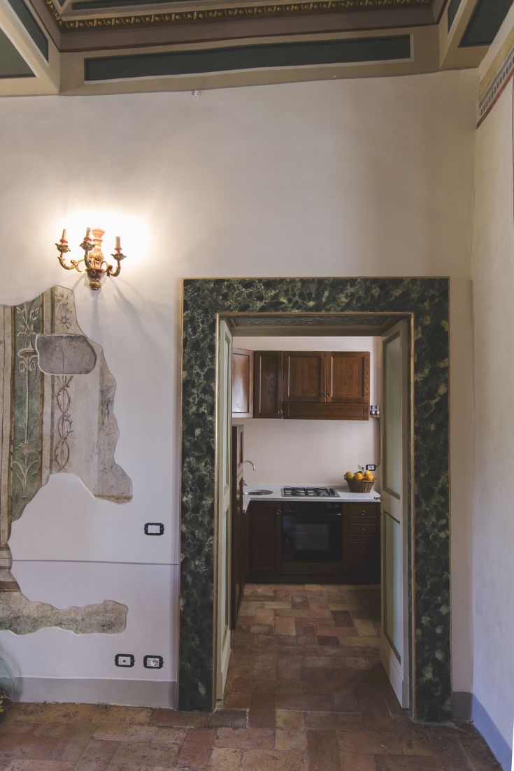 Interno di un palazzo con un ingresso discreto che porta alla cucina.