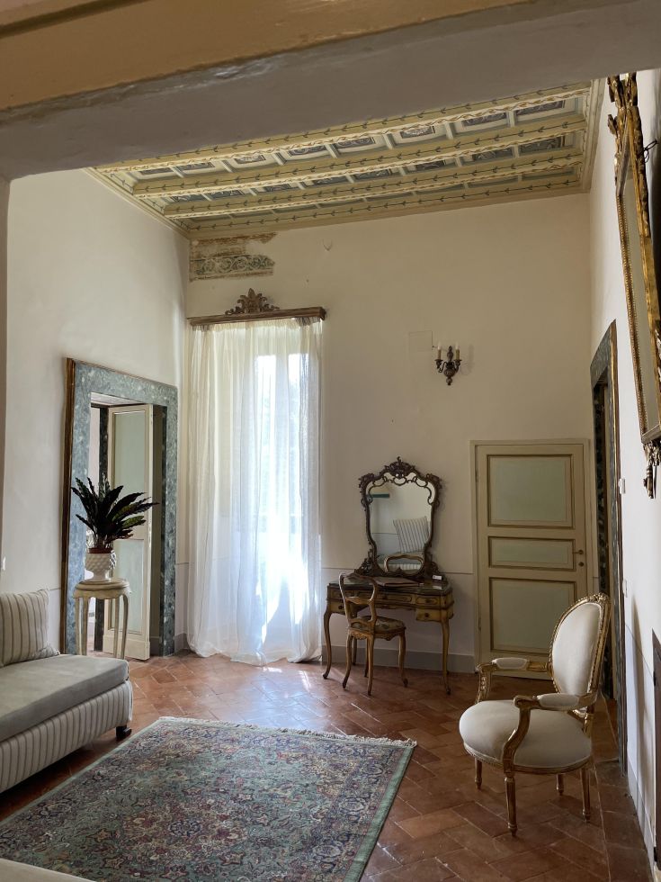 Interni di un palazzo con elementi storici e arredi moderni in un'atmosfera accogliente.