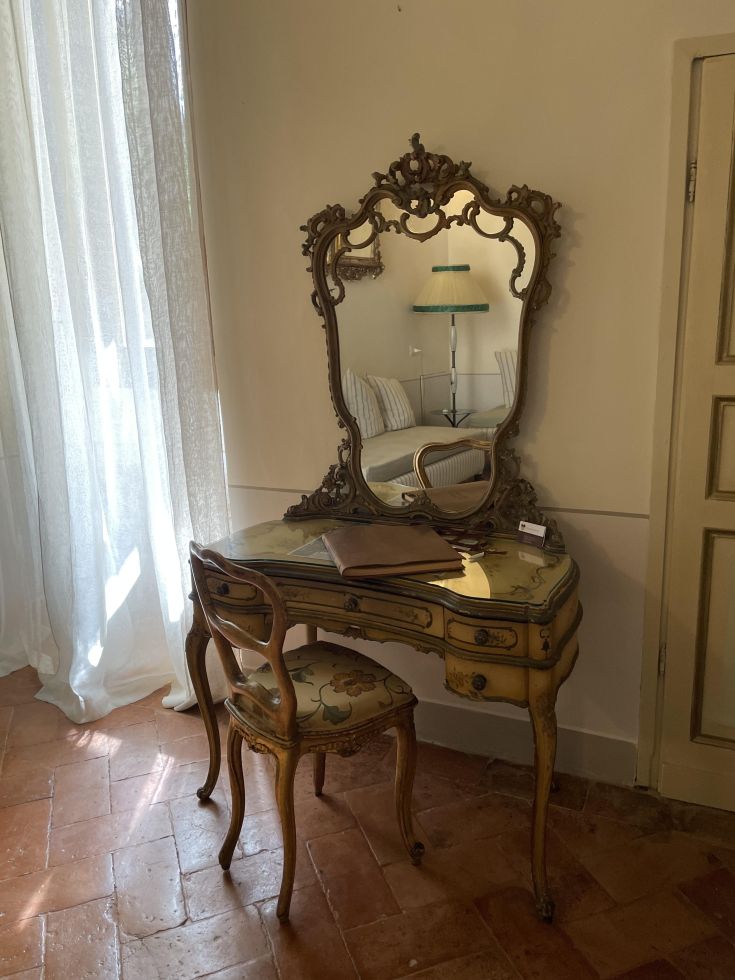 Un mobile vanità in legno con specchio, situato in un ambiente luminoso e ben curato.