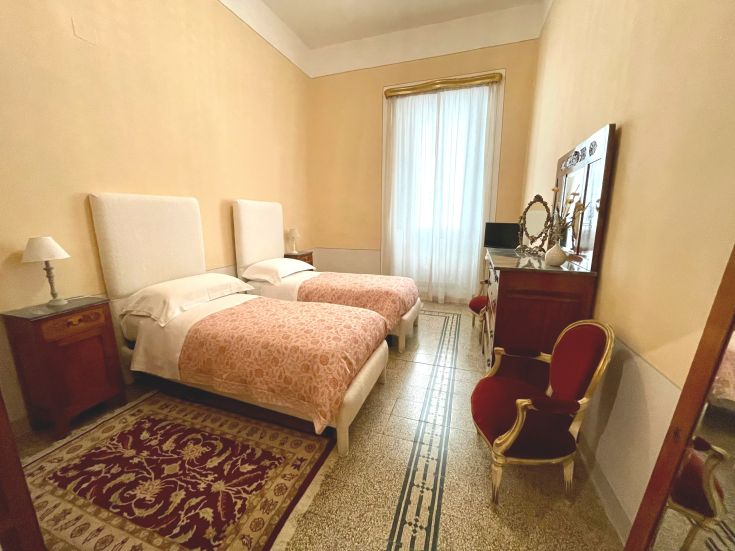 Camera semplice in un appartamento ristrutturato, con letti singoli e arredamento discreto.