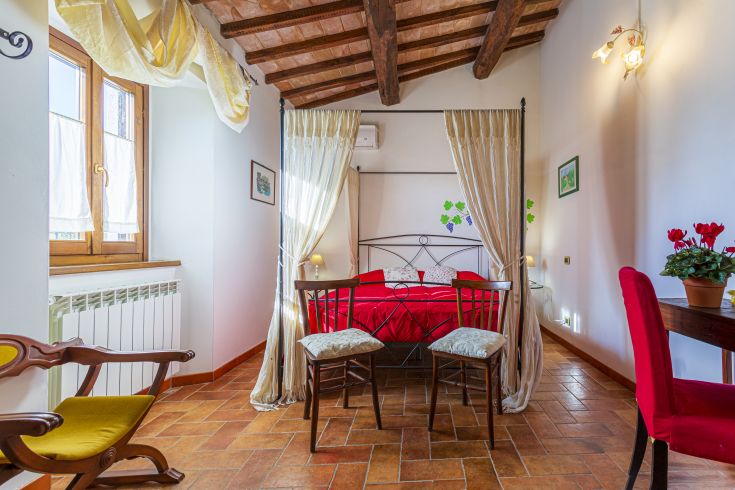 Stanza confortevole con letto a baldacchino in legno e arredamento in stile rustico.