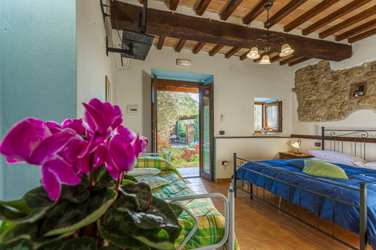 Una camera confortevole che si affaccia su un giardino fiorito, ideale per un soggiorno tranquillo.