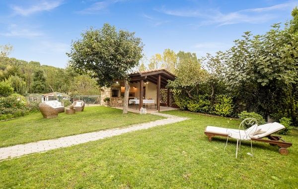 Ein einladender grüner Bereich mit einem gepflegten Garten und einer Außenküche, perfekt für Entspannungsmomente.