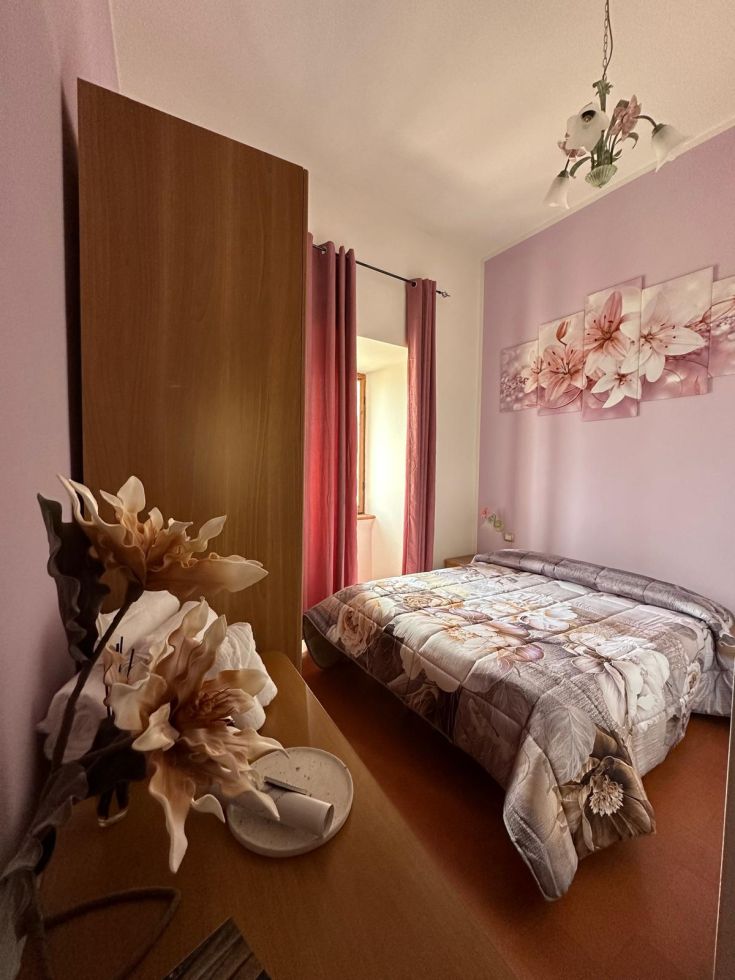 Camera semplice con decorazioni floreali, letti comodi e un'atmosfera tranquilla.