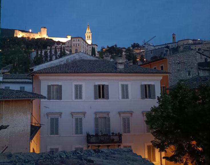 Evening scene of Spoleto, featuring a illuminated castle in a peaceful and picturesque setting.