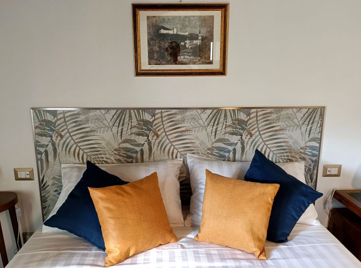 Cozy room with a simple headboard and vibrant pillows, ideal for peaceful moments.