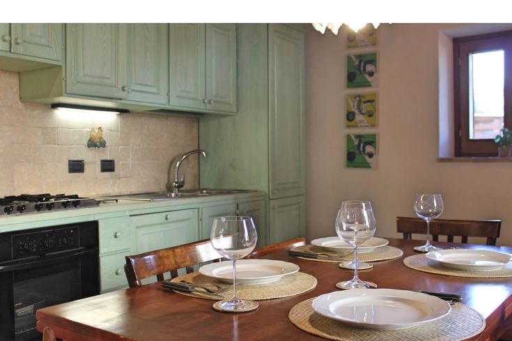 Warm kitchen with wooden details and modern appliances, perfect for preparing meals with company.