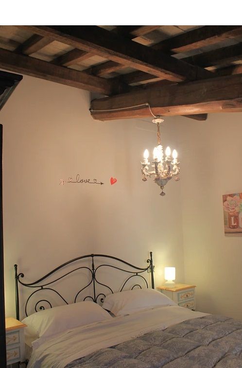 A peaceful bedroom featuring a double bed and a chandelier, set in a relaxing atmosphere.