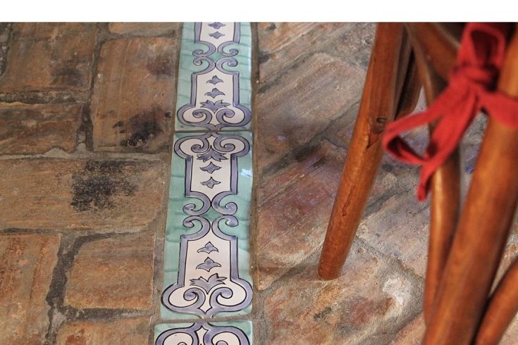 A ceramic mosaic stands out on a floor made of ancient stonework.