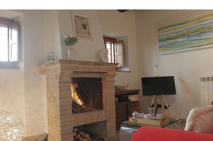 A cozy corner with a lit fireplace, simply furnished, perfect for relaxation moments.