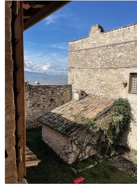 A stone cottage located in the Umbrian countryside, surrounded by a serene garden and relaxing views.