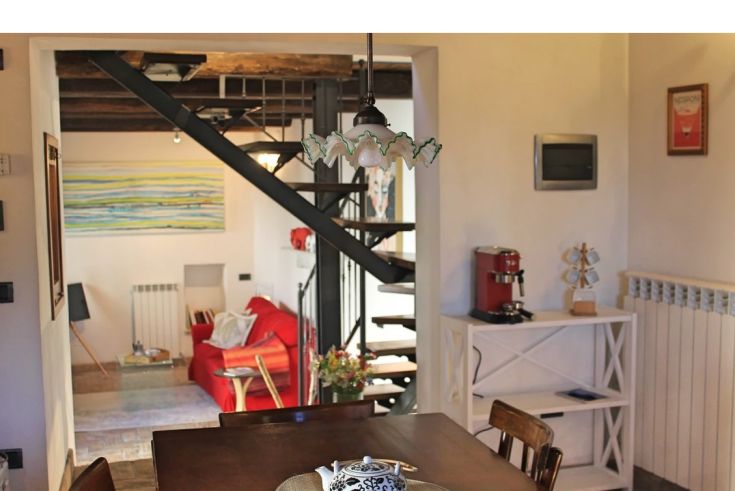 Cozy Umbrian cottage with simple furniture and historic details, located in a peaceful setting.