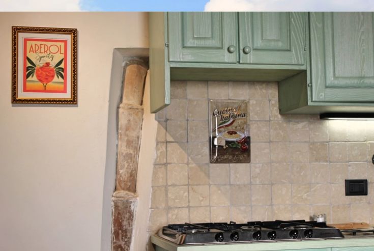 Simple and bright kitchen with wooden elements and modest decorations, perfect for relaxed meal preparation.