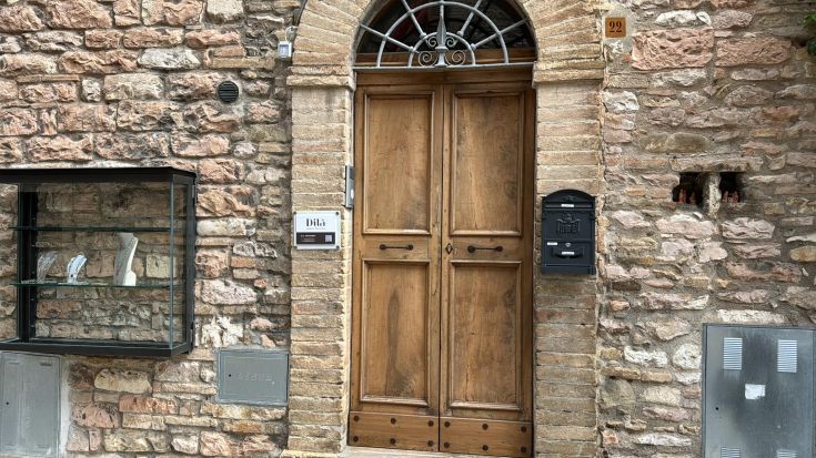 Holztür mit Dekorationen, gelegen in einer ruhigen städtischen Umgebung, neben einem Fenster aus Glas.