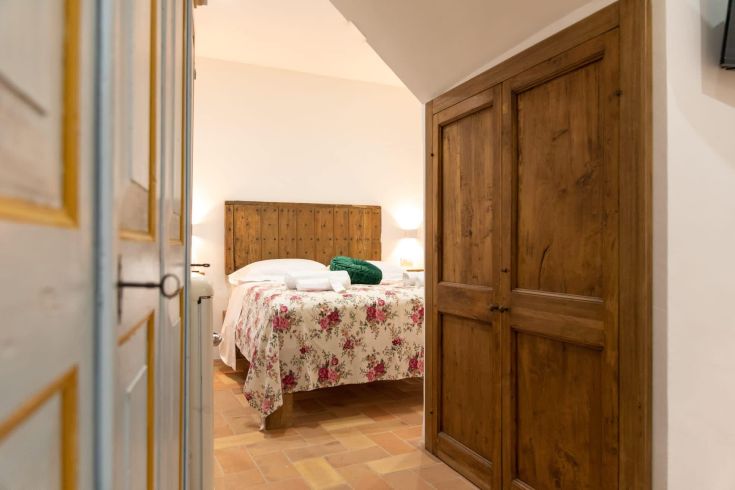 Geräumiges Zimmer mit einem Doppelbett, rustikaler Einrichtung und ruhiger Atmosphäre.